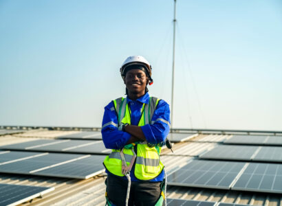 smiling man standing among rooftop solar panels
