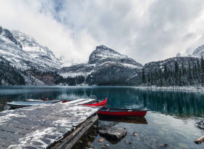 Rocky mountains with red canoe at wooden pier on Lake O'hara at Yoho national park